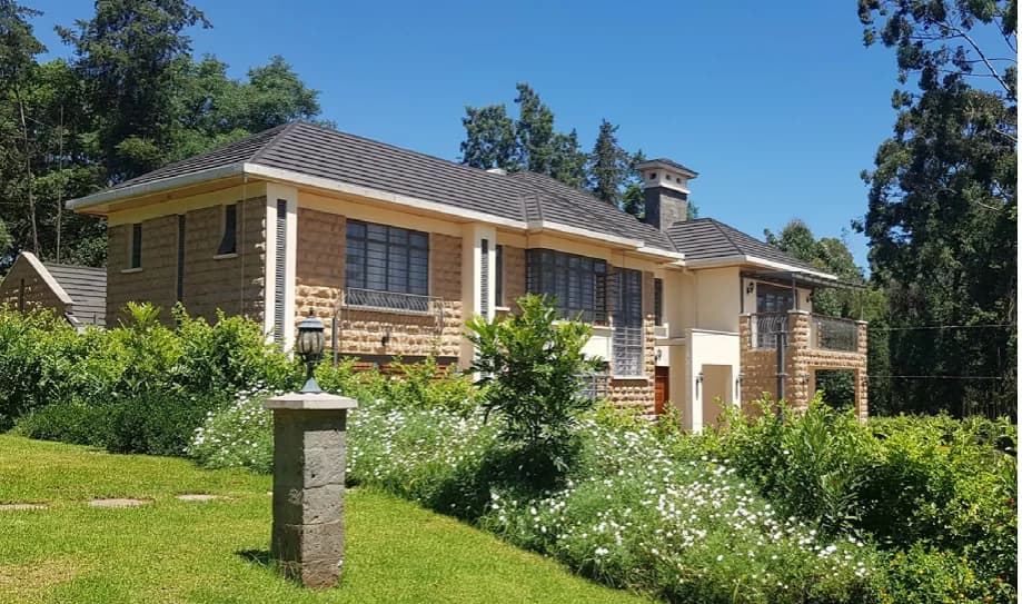 Completed single-storey residential bungalow with natural stone facing, tiled hipped roof and landscaped grounds
